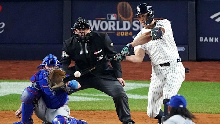 Oct 30, 2024; New York, New York, USA; New York Yankees designated hitter Giancarlo Stanton (27) hits an RBI sacrifice fly during the sixth inning against the Los Angeles Dodgers in game four of the 2024 MLB World Series at Yankee Stadium.
