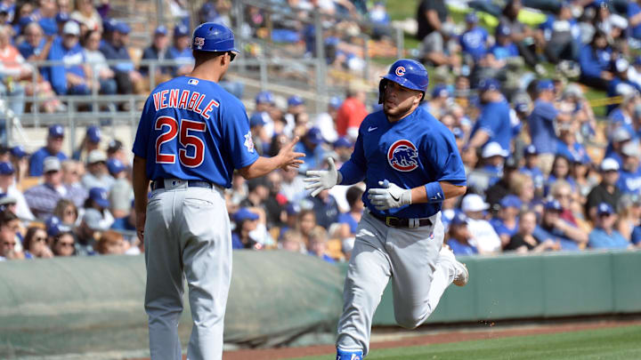 Feb 23, 2020; Phoenix, Arizona, USA; Chicago Cubs catcher Victor Caratini (7) slaps hands with Chicago Cubs third base coach Will Venable (25) after hitting a solo home run against the Los Angeles Dodgers during the fourth inning of a spring training game at Camelback Ranch.