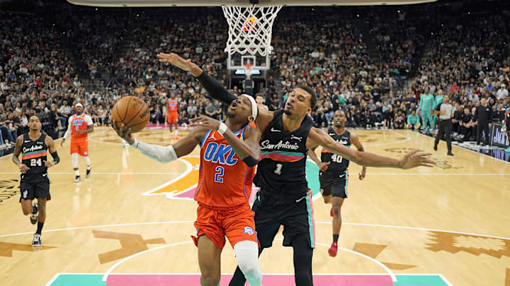 Dec 23, 2025; San Antonio, Texas, USA; Oklahoma City Thunder guard Shai Gilgeous-Alexander (2) drives to the basket past San Antonio Spurs forward Victor Wembanyama (1) during the first half at Frost Bank Center. Mandatory Credit: Scott Wachter-Imagn Images