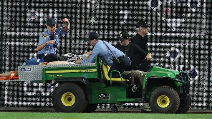Apr 30, 2025; Pittsburgh, Pennsylvania, USA;  Stadium security and Pittsburgh Pirates medical personnel cart a fan who fell from the stands to the field to an ambulance as the Pirates batted against the Chicago Cubs during the seventh inningat PNC Park. Mandatory Credit: Charles LeClaire-Imagn Images