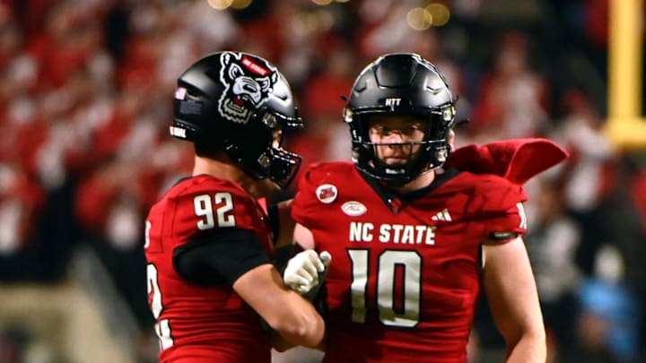 Nov 4, 2023; Raleigh, North Carolina, USA; North Carolina State Wolfpack linebacker Caden Fordham (10) and teammate Aiden Arias (92) react to a fourth down stop during the second half against the Miami Hurricanes at Carter-Finley Stadium.  Mandatory Credit: Rob Kinnan-Imagn Images