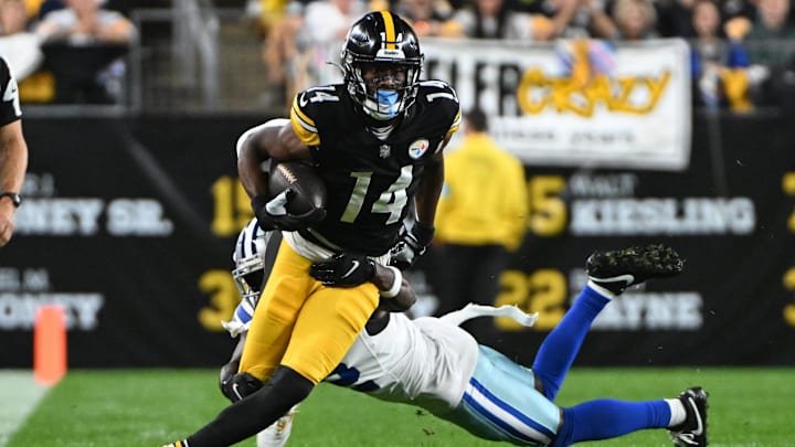 Oct 6, 2024; Pittsburgh, Pennsylvania, USA; Pittsburgh Steelers wide receiver George Pickens (14) breaks a tackle by Dallas Cowboys cornerback Jourdan Lewis (2) during the first quarter at Acrisure Stadium. Mandatory Credit: Barry Reeger-Imagn Image