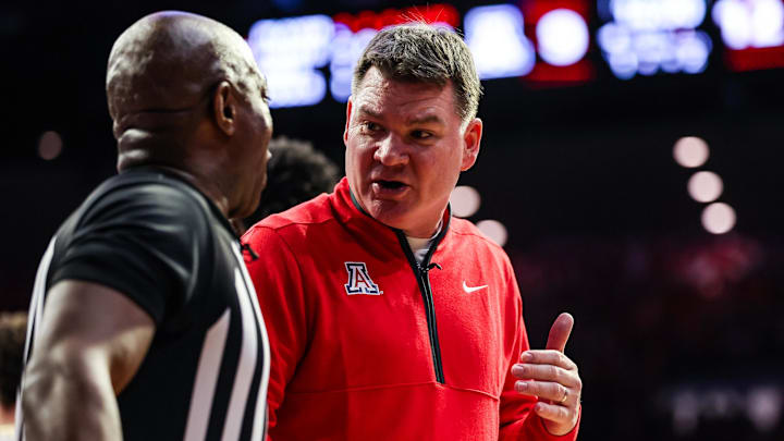 Jan 14, 2026; Tucson, Arizona, USA; Arizona Wildcats head coach Tommy Lloyd talks with the referee during the first half of the game against the Arizona State Sun Devils at McKale Memorial Center. Mandatory Credit: Aryanna Frank-Imagn Images