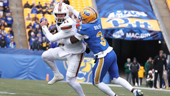 Nov 29, 2025; Pittsburgh, Pennsylvania, USA;  Miami Hurricanes quarterback Carson Beck (11) runs the ball as Pittsburgh Panthers linebacker Rasheem Biles (3) tackles during the first quarter at Acrisure Stadium. Mandatory Credit: Charles LeClaire-Imagn Images