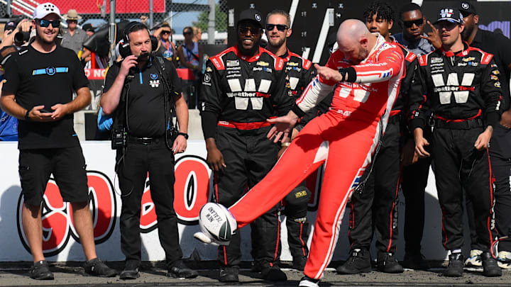 Aug 10, 2025; Watkins Glen, New York, USA; NASCAR Cup Series driver Shane van Gisbergen (88) punts a rugby ball into the stands following his victory in the Go Bowling at The Glen at Watkins Glen International.