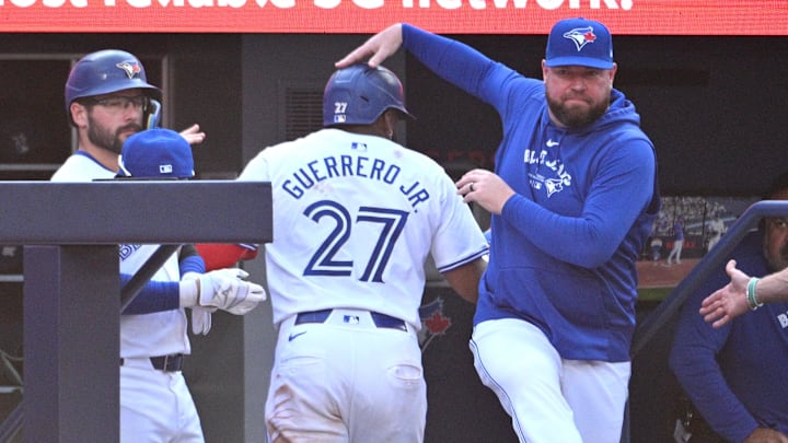 Sep 14, 2024; Toronto, Ontario, CAN;  Toronto Blue Jays first baseman Vladimir Guerrero Jr. (27) is greeted at the dugout entrance by manager John Schneider (14) after scoring a run against the St. Louis Cardinals in the seventh inning at Rogers Centre. 