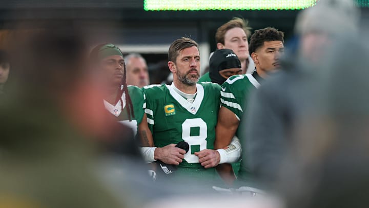Jan 5, 2025; East Rutherford, New Jersey, USA; New York Jets quarterback Aaron Rodgers (8) stands with teammates during the national anthem before the game against the Miami Dolphins at MetLife Stadium. Mandatory Credit: Vincent Carchietta-Imagn Images