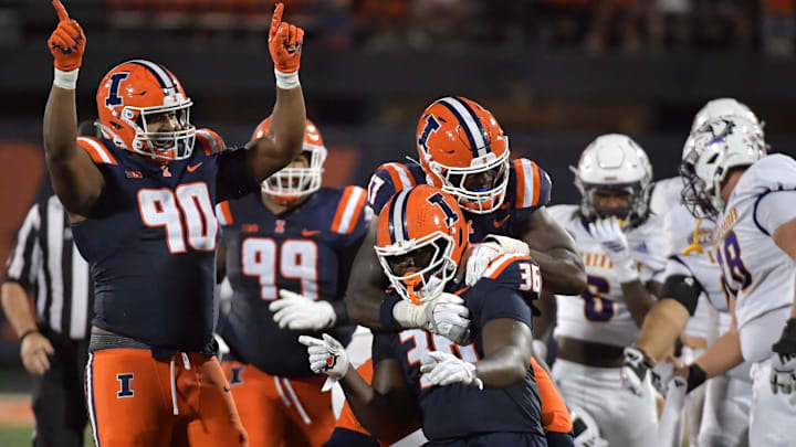 Aug 29, 2025; Champaign, Illinois, USA;  Illinois Fighting Illini linebacker Gabe Jacas (17) jumps on teammate Illinois Fighting Illini defensive lineman Eli Coenen (96) after a sack on Western Illinois Leathernecks quarterback Chris Irvin (5) during the first half at Memorial Stadium. Mandatory Credit: Ron Johnson-Imagn Images