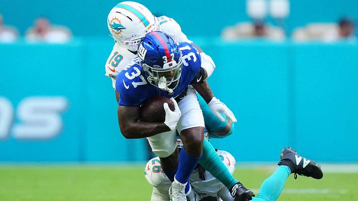 Aug 22, 2026; Miami Gardens, Florida, USA;  Miami Dolphins linebacker Kyle Louis (19) tackles New York Giants running back Damon Bankston (37) during the third quarter of a preseason game at Hard Rock Stadium.  Mandatory Credit: Rich Storry-Imagn Images