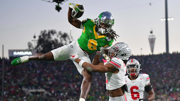 Jan 1, 2025; Pasadena, CA, USA;  Oregon Ducks running back Noah Whittington (6) runs against Ohio State Buckeyes cornerback Davison Igbinosun (1) in the second half in the 2025 Rose Bowl college football quarterfinal game at Rose Bowl Stadium. Mandatory Credit: Gary A. Vasquez-Imagn Images