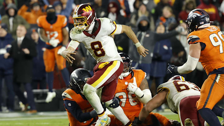 Nov 30, 2025; Landover, Maryland, USA; Washington Commanders quarterback Marcus Mariota (8) runs with the ball as Denver Broncos defensive end John Franklin-Myers (98) and Broncos linebacker Nik Bonitto (15) attempt a tackle during overtime at Northwest Stadium. Mandatory Credit: Geoff Burke-Imagn Images