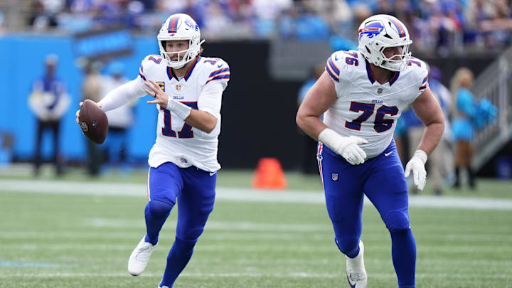 Oct 26, 2025; Charlotte, North Carolina, USA; Buffalo Bills quarterback Josh Allen (17) scrambles behind guard David Edwards (76) during the first half against the Carolina Panthers at Bank of America Stadium. Mandatory Credit: Jim Dedmon-Imagn Images