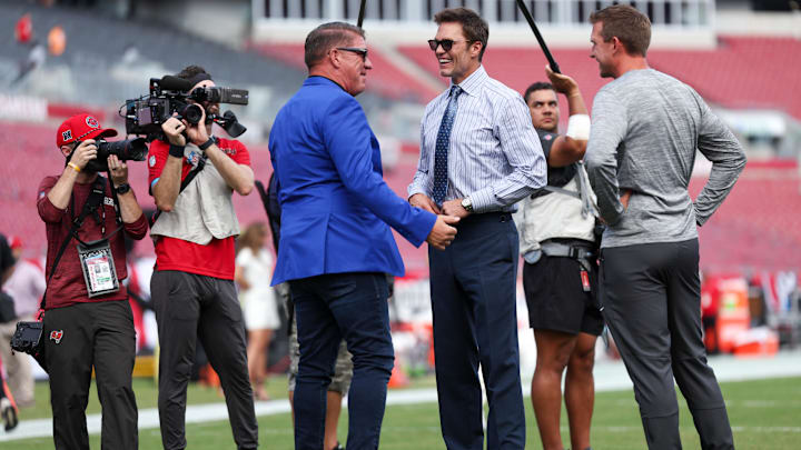 Sep 29, 2024; Tampa, Florida, USA;   Fox NFL broadcaster and former NFL quarterback Tom Brady speaks to Tampa Bay Buccaneers general manager Jason Licht before a game against the Philadelphia Eagles at Raymond James Stadium. Mandatory Credit: Nathan Ray Seebeck-Imagn Images