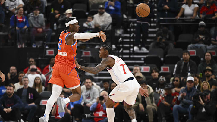Nov 2, 2024; Inglewood, California, USA; Oklahoma City Thunder guard Shai Gilgeous-Alexander (2) passes against LA Clippers guard Kevin Porter Jr. (77) during the first half at Intuit Dome. Mandatory Credit: Jonathan Hui-Imagn Images