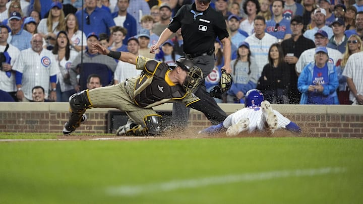 Oct 2, 2025; Chicago, Illinois, USA; San Diego Padres catcher Freddy Fermin (54) tags out Chicago Cubs second baseman Nico Hoerner (2) during the seventh inning of game three of the Wildcard round for the 2025 MLB playoffs at Wrigley Field. Mandatory Credit: David Banks-Imagn Images