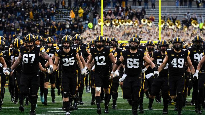 The Iowa Hawkeyes swarm to the Floyd of Rosedale Trophy after defeating the Minnesota Golden Gophers Oct. 25, 2025 at Kinnick Stadium in Iowa City, Iowa.