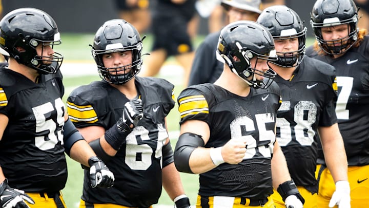 Aug 9, 2025; Iowa offensive linemen Trevor Lauck (59) Leighton Jones (64) Logan Jones (65) Kade Pieper (58) and Gennings Dunker (67) huddle up with quarterback Hank Brown (9) during the Hawkeyes Kids Day NCAA football open practice at Kinnick Stadium in Iowa City, Iowa. Mandatory Credit: Joseph Cress for the Des Moines Register