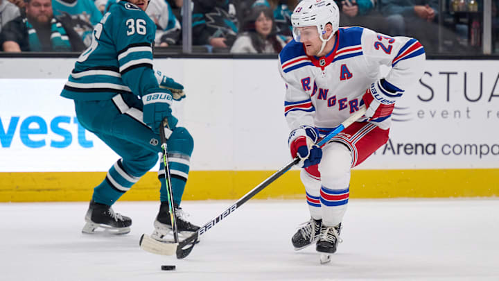 Mar 29, 2025; San Jose, California, USA; New York Rangers defenseman Adam Fox (23) plays the puck against San Jose Sharks defenseman Lucas Carlsson (36) during the first period at SAP Center at San Jose. Mandatory Credit: Robert Edwards-Imagn Images