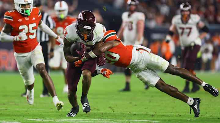 Sep 27, 2024; Miami Gardens, Florida, USA; Virginia Tech Hokies running back Bhayshul Tuten (33) runs with the football against Miami Hurricanes defensive back Zaquan Patterson (20) during the fourth quarter at Hard Rock Stadium. Mandatory Credit: Sam Navarro-Imagn Images