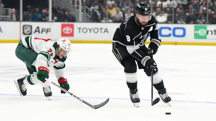 Apr 15, 2024; Los Angeles, California, USA; LA Kings defenseman Drew Doughty (8) and Minnesota Wild center Marco Rossi (23) battle for the puck in the second period at Crypto.com Arena. Mandatory Credit: Kirby Lee-Imagn Images