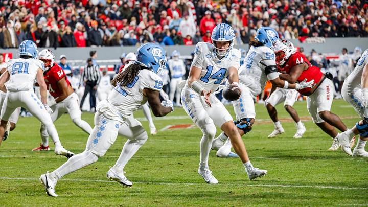 North Carolina Tar Heels quarterback Max Johnson (14) passes the ball to running back Demon June (12) during the second half of the game against NC State Wolfpack North Carolina Tar Heels quarterback Max Johnson (14) passes the ball to running back Demon June (12) during the second half of the game against NC State Wolfpack
