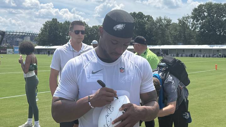 Eagles Saquon Barkley signs a football for a fan after a training camp practice in August, 2026. Eagles Saquon Barkley signs a football for a fan after a training camp practice in August, 2026.