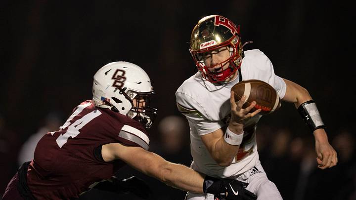 Bergen Catholic's Trey Tagliaferri (12) attempts to evade an oncoming pass rush. Bergen Catholic's Trey Tagliaferri (12) attempts to evade an oncoming pass rush.