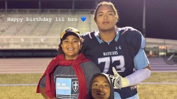 Champ Taulealea, a UW commit, shares a moment with family.