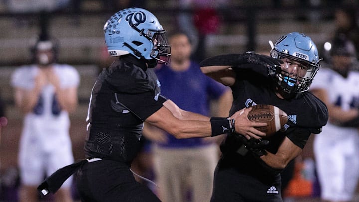 Pueblo West's Zach Duran, right, takes a handoff from teammate Gavin Lockett during a matchup with Mesa Ridge at Cyclone Stadium on Friday, Oct. 11, 2024.