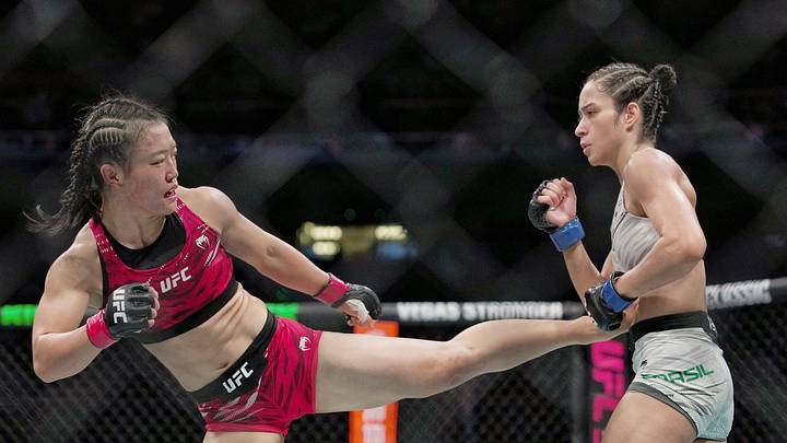 La luchadora china Shi Ming (i) golpea a la brasileña Bruna Brasil.