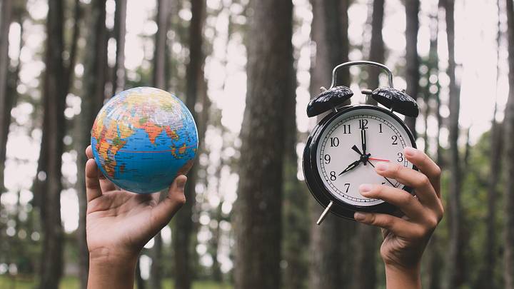 Globe and clock in forest scene Globe and clock in forest scene