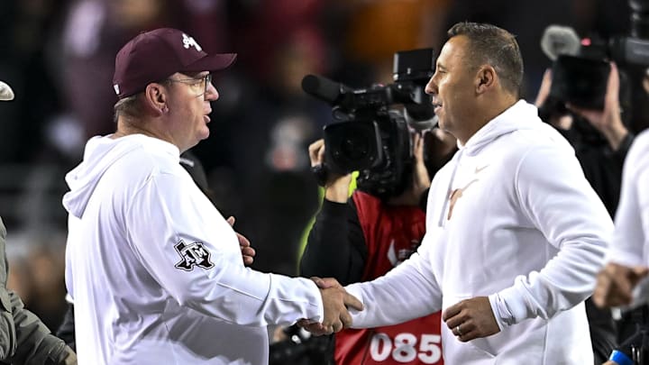 Nov 30, 2024; College Station, Texas, USA; Texas A&M Aggies head coach Mike Elko, left, shakes hands with Texas Longhorns head coach Steve Sarkisian after the game. The Longhorns defeated the Aggies 17-7. at Kyle Field. Mandatory Credit: Maria Lysaker-Imagn Images 