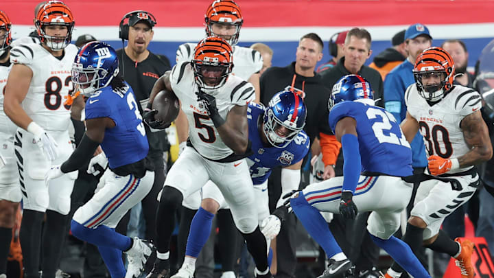 Oct 13, 2024; East Rutherford, New Jersey, USA; Cincinnati Bengals wide receiver Tee Higgins (5) runs with the ball against New York Giants cornerback Deonte Banks (3) and linebacker Micah McFadden (41) and safety Jason Pinnock (27) during the second quarter at MetLife Stadium.  