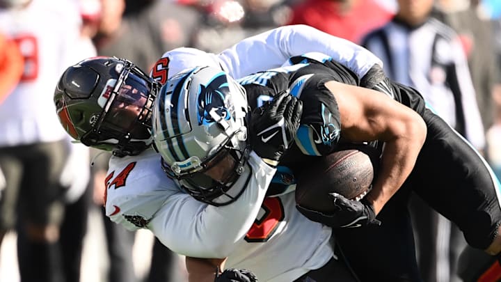 Jan 7, 2024; Charlotte, North Carolina, USA; Carolina Panthers running back Chuba Hubbard (30) is tackled by Tampa Bay Buccaneers linebacker Lavonte David (54) in the second quarter at Bank of America Stadium. Mandatory Credit: Bob Donnan-Imagn Images