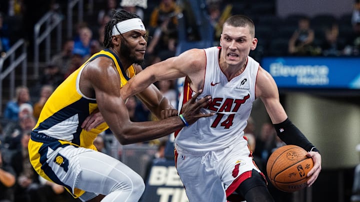 Nov 15, 2024; Indianapolis, Indiana, USA; Miami Heat guard Tyler Herro (14) dribbles the ball while Indiana Pacers forward Jarace Walker (5) defends in the second half at Gainbridge Fieldhouse. Mandatory Credit: Trevor Ruszkowski-Imagn Images