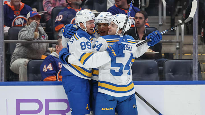 Nov 22, 2025; Elmont, New York, USA;  St. Louis Blues center Brayden Schenn (10) celebrates with left wing Pavel Buchnevich (89) and right wing Dalibor Dvorsky (54) after scoring a goal in the first period against the New York Islanders at UBS Arena. Mandatory Credit: Wendell Cruz-Imagn Images
