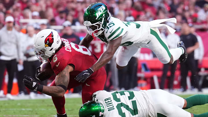 Nov 10, 2024; Glendale, Arizona, USA; New York Jets safety Jalen Mills (35) and New York Jets cornerback Isaiah Oliver (23) tackle Arizona Cardinals running back James Conner (6) during the second half at State Farm Stadium.