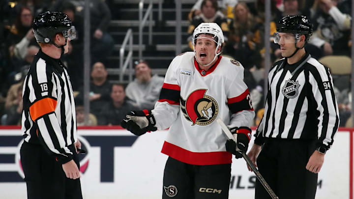 Jan 11, 2025; Pittsburgh, Pennsylvania, USA;  Ottawa Senators center Nick Cousins (21) protests to referee Tom Chmielewski (18) after being called for committing a penalty against the Pittsburgh Penguins during the second period at PPG Paints Arena. Mandatory Credit: Charles LeClaire-Imagn Images