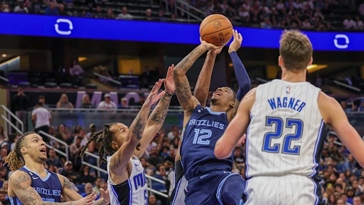 Oct 11, 2022; Orlando, Florida, USA; Memphis Grizzlies guard Ja Morant (12) goes to the basket in front of Orlando Magic guard Cole Anthony (50) during the second half at Amway Center. Mandatory Credit: Mike Watters-Imagn Images