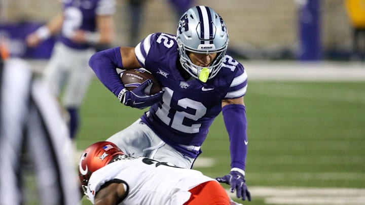 Nov 23, 2024; Manhattan, Kansas, USA; Kansas State Wildcats wide receiver Tre Spivey (12) is tackled by Cincinnati Bearcats cornerback Ormanie Arnold (8) during the third quarter at Bill Snyder Family Football Stadium. Mandatory Credit: Scott Sewell-Imagn Images