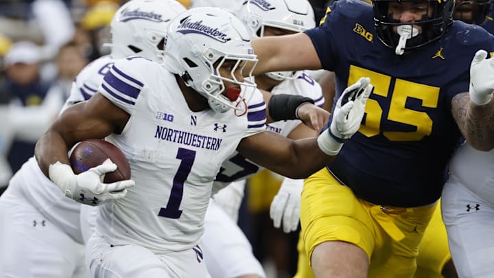 Nov 23, 2024; Ann Arbor, Michigan, USA; Northwestern Wildcats running back Cam Porter (1) runs the ball against the Michigan Wolverines in the first half at Michigan Stadium. Mandatory Credit: Rick Osentoski-Imagn Images Nov 23, 2024; Ann Arbor, Michigan, USA; Northwestern Wildcats running back Cam Porter (1) runs the ball against the Michigan Wolverines in the first half at Michigan Stadium. Mandatory Credit: Rick Osentoski-Imagn Images