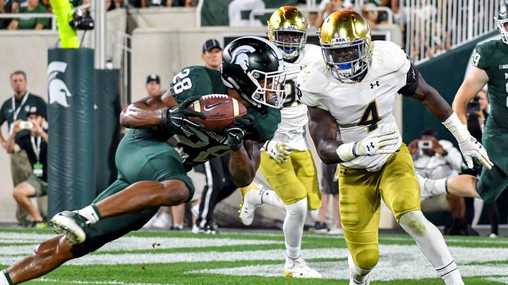 Sep 23, 2017; East Lansing, MI, USA; Michigan State Spartans tailback Madre London (28) catches a pass as Notre Dame Fighting Irish linebacker Te'von Coney (4) prepares to tackle in the fourth quarter at Spartan Stadium. Mandatory Credit: Matt Cashore-Imagn Images