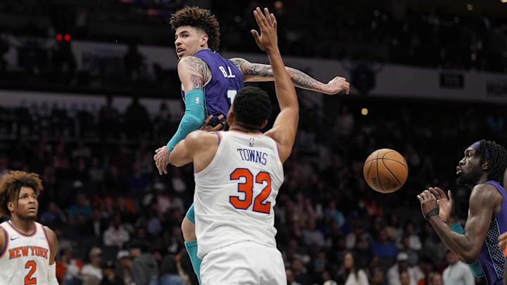 Mar 20, 2025; Charlotte, North Carolina, USA; Charlotte Hornets guard LaMelo Ball (1) with a back the behind pass to center Mark Williams (5) in front of New York Knicks center Karl-Anthony Towns (32) during the second half at Spectrum Center. Mandatory Credit: Jim Dedmon-Imagn Images