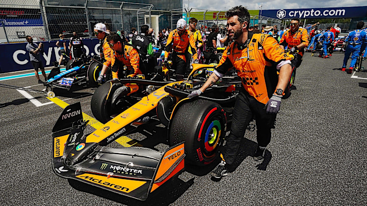 May 4, 2024; Miami Gardens, Florida, USA; Crewmembers push the car of McLaren driver Lando Norris (4) on the grid before the F1 Sprint Race at Miami International Autodrome. Mandatory Credit: John David Mercer-Imagn Images