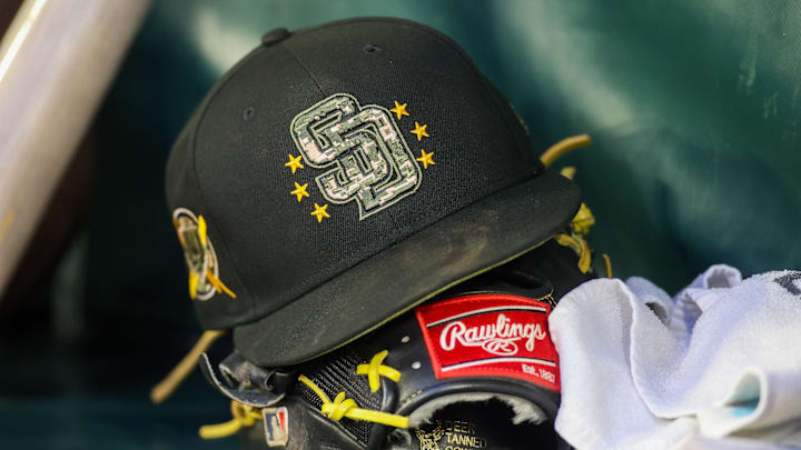 Atlanta, Georgia, USA; A detailed view of a San Diego Padres hat and glove on the bench against the Atlanta Braves in the third inning at Truist Park.