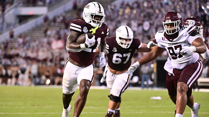 Aug 31, 2024; Starkville, Mississippi, USA; Mississippi State Bulldogs running back Davon Booth (21) runs the ball while defended by Eastern Kentucky Colonels defensive lineman Ryan Jackson (97) during the third quarter at Davis Wade Stadium at Scott Field. Mandatory Credit: Matt Bush-Imagn Images