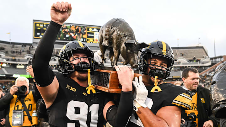 Oct 25, 2025; Iowa City, Iowa, USA; Iowa Hawkeyes defensive lineman Jonah Pace (91) and defensive lineman Bryce Hawthorne (96) carry off the Floyd of Rosedale trophy after their victory over the Minnesota Golden Gophers at Kinnick Stadium. Mandatory Credit: Jeffrey Becker-Imagn Images