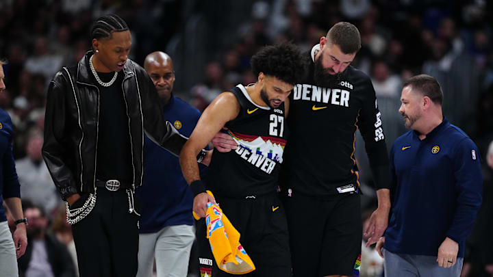 Mar 6, 2026; Denver, Colorado, USA; Denver Nuggets guard Jamal Murray (27) is helped off the court by guard Peyton Watson (8) and center Jonas Valanciunas (17) during the second quarter against the New York Knicks at Ball Arena. Mandatory Credit: Ron Chenoy-Imagn Images