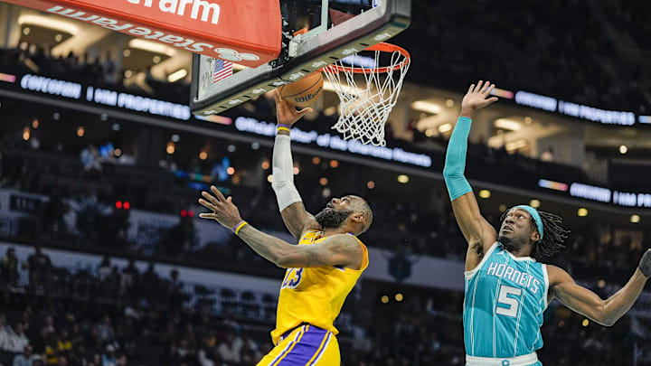 Jan 27, 2025; Charlotte, North Carolina, USA;  Los Angeles Lakers forward LeBron James (23) makes a layup past Charlotte Hornets center Mark Williams (5) during the first quarter at the Spectrum Center. Mandatory Credit: Jim Dedmon-Imagn Images