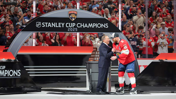 Jun 17, 2025; Sunrise, Florida, USA; Gary Bettman, NHL Commissioner, presents Florida Panthers center Sam Bennett (9) the Conn Smythe Trophy after winning game six of the 2025 Stanley Cup Final against the Edmonton Oilers at Amerant Bank Arena. Mandatory Credit: Sam Navarro-Imagn Images